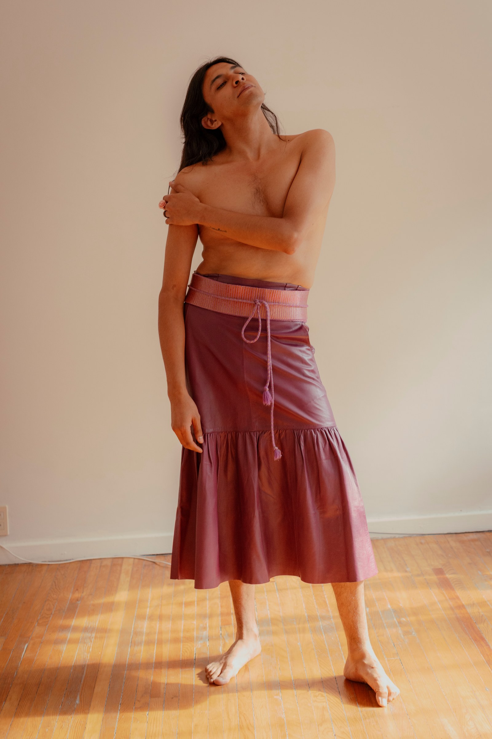 Woman standing in a long skirt in a softly lit room