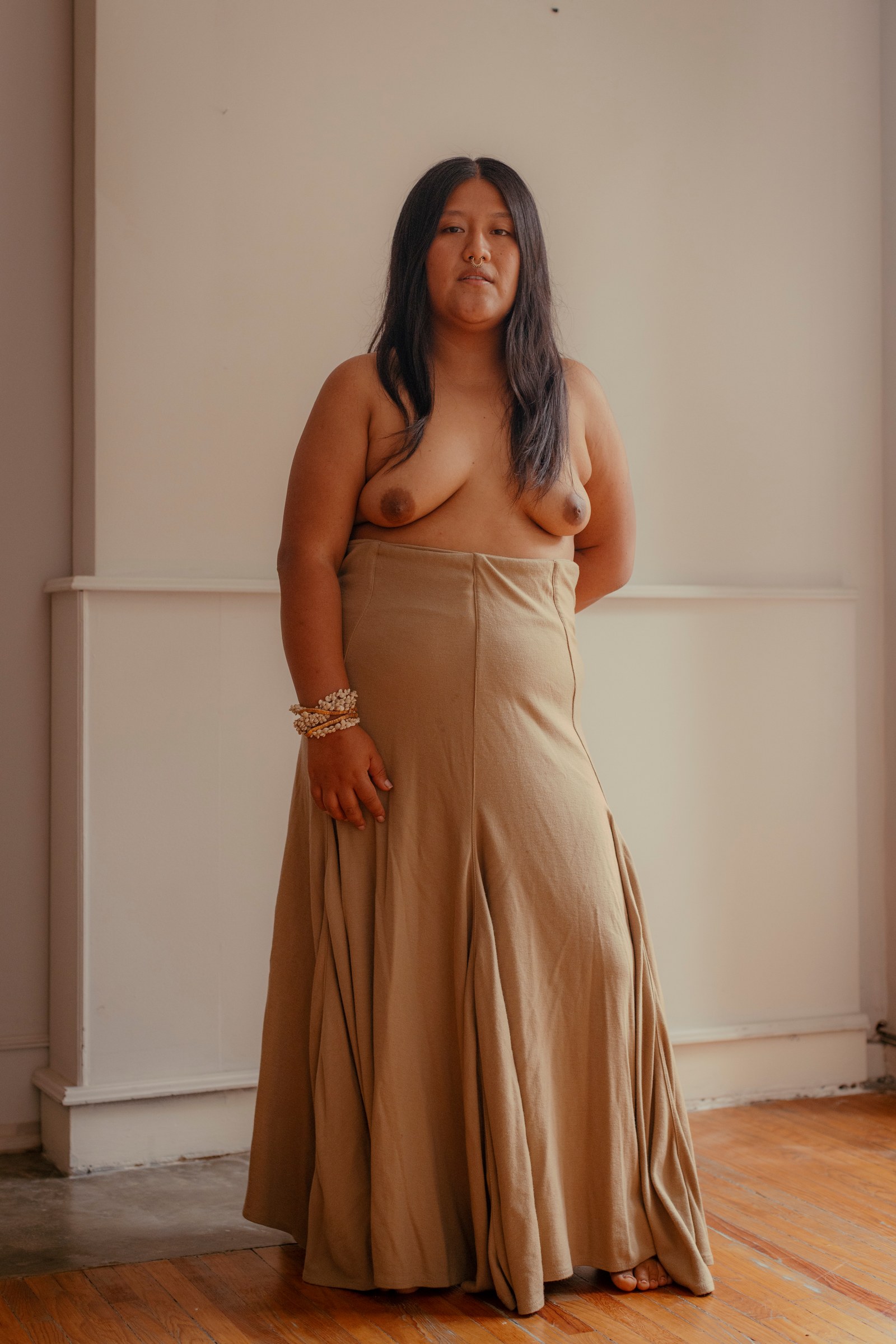 Woman standing in a backless top with her hands behind her